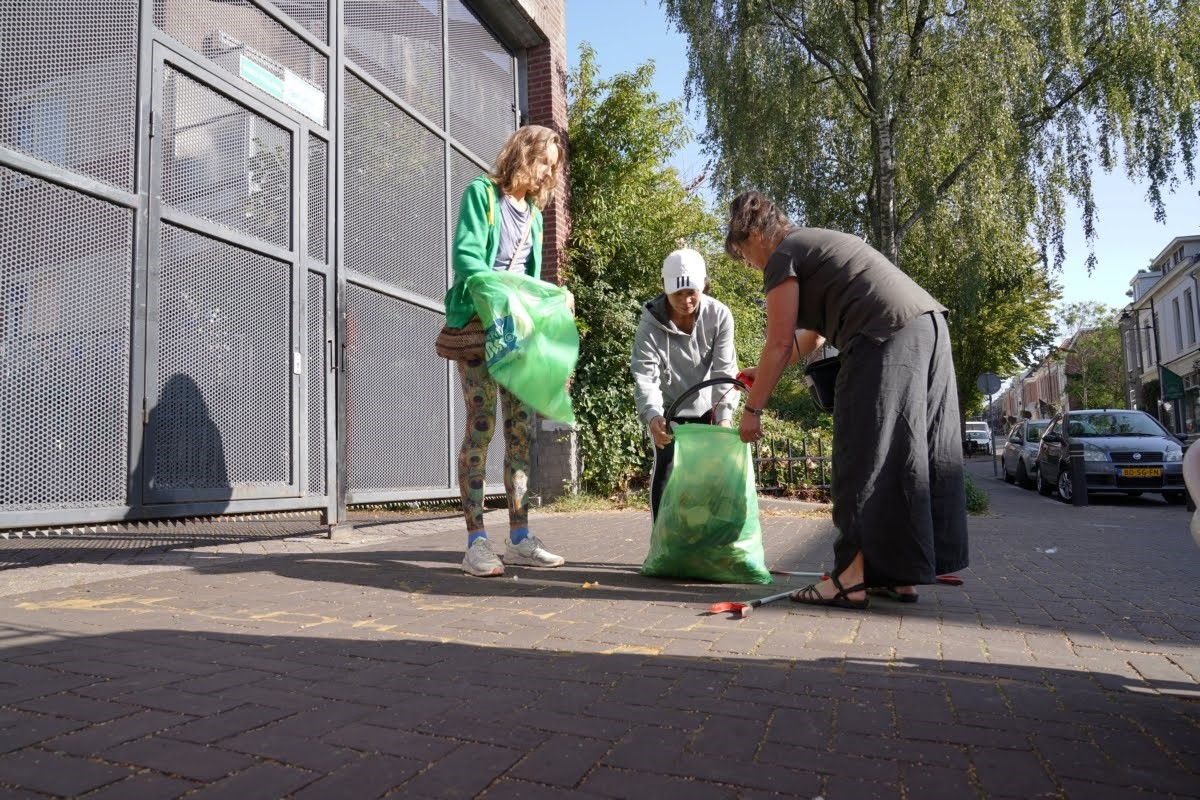 Drie vrouwen stoppen afval in afvalzakken